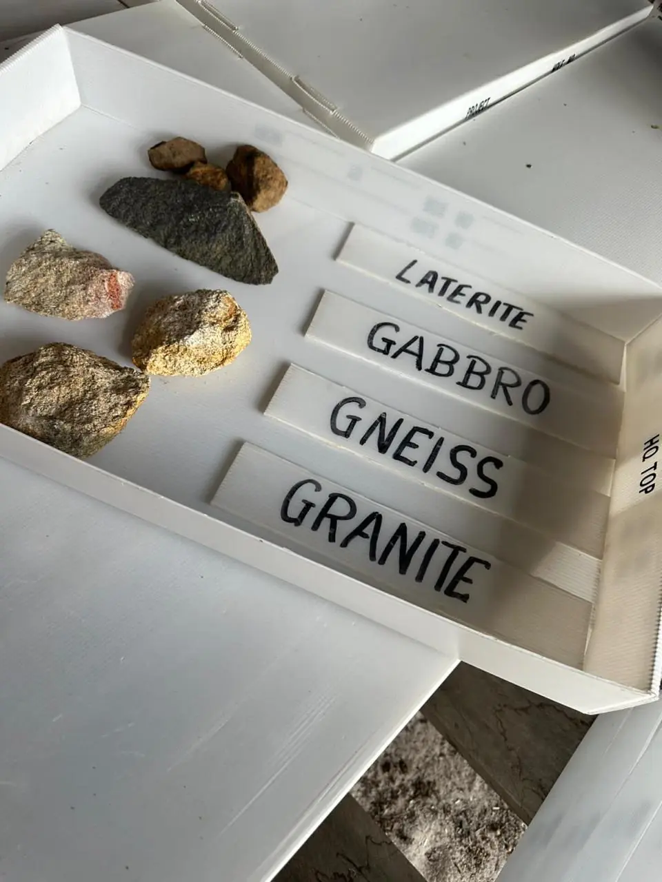 Labelled sample trays showing the four rock types encountered — Laterite, Gabbro, Gneiss and Granite.