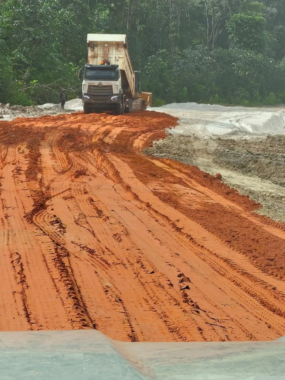 A SEBA-liveried HOWO tipper working a red-earth haul road out of the quarry.