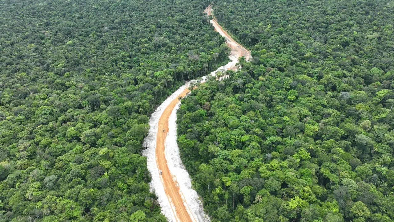 The red-earth access road we built, carved through dense green forest toward the Essequibo.