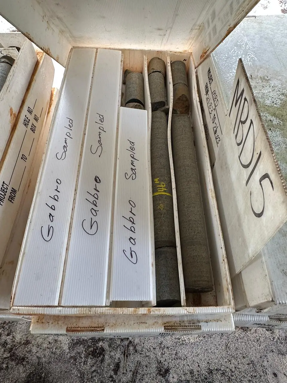 Core box labelled "Gabbro Sampled" beside box MBD15, with split grey gabbro cores exposed down the centre.