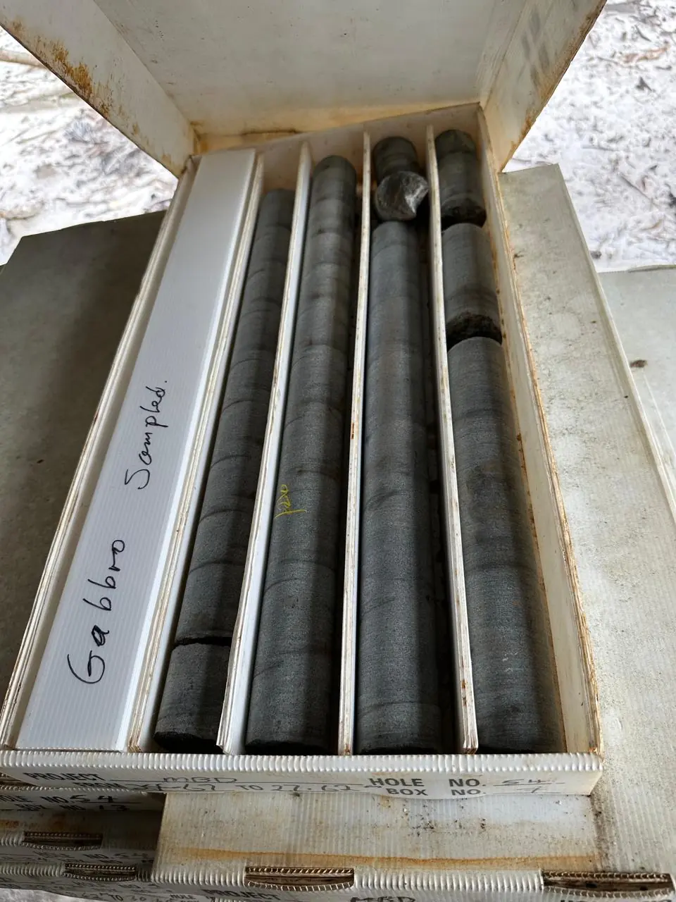 Close-up of Hole No. 54 — four gabbro cores marked "Gabbro Sampled" laid out in a white polypropylene core tray.