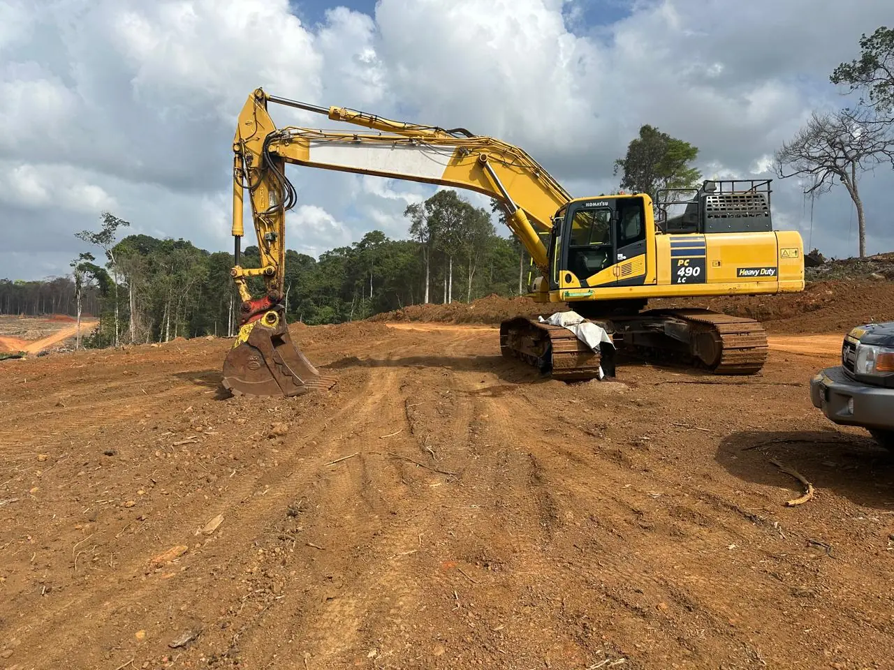 The yellow PC490 excavator working on the cleared pit floor.